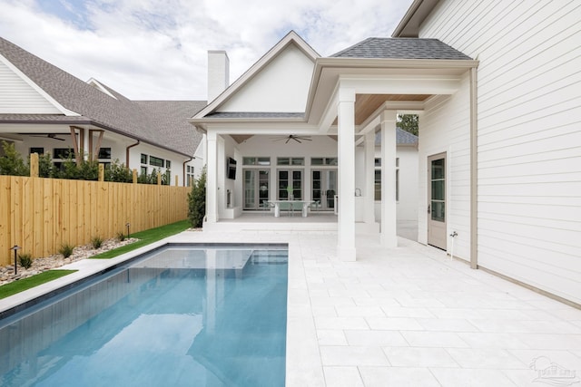 back of property featuring a ceiling fan, a chimney, roof with shingles, fence, and a patio area