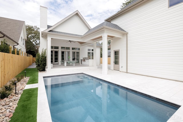 back of property with a fenced in pool, a ceiling fan, a fenced backyard, roof with shingles, and a patio area