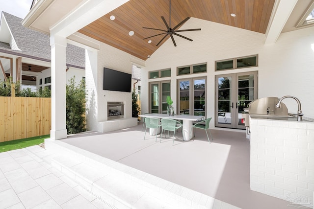 view of patio featuring french doors, a fireplace, area for grilling, and ceiling fan