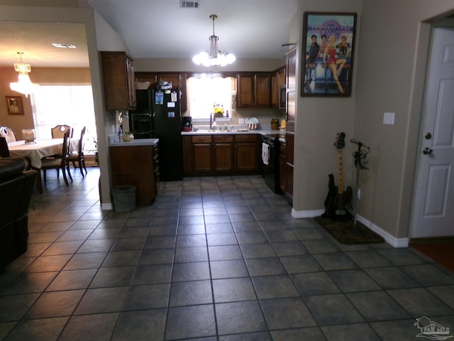 kitchen with black appliances, a notable chandelier, a wealth of natural light, and pendant lighting