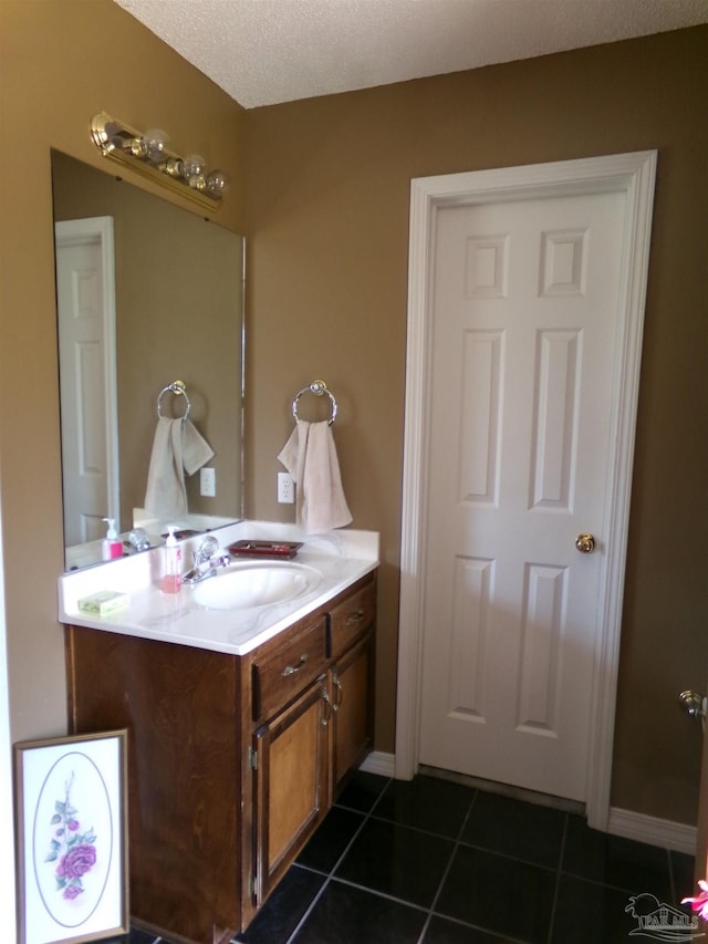 bathroom with a textured ceiling, tile patterned floors, and vanity