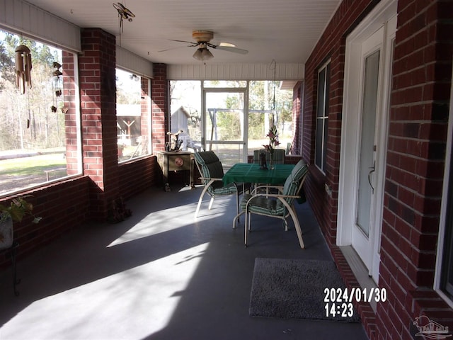 unfurnished sunroom featuring ceiling fan and a healthy amount of sunlight