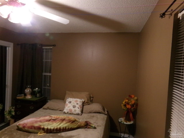 bedroom featuring ceiling fan and a textured ceiling