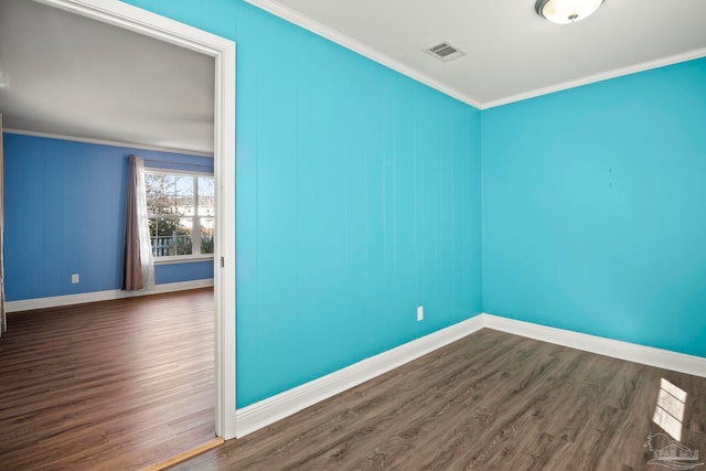 empty room with dark wood-type flooring and ornamental molding