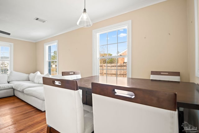 dining room with crown molding and light wood-type flooring