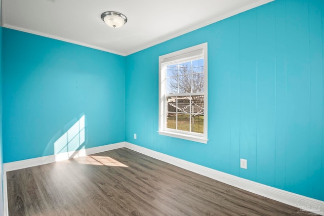 spare room with hardwood / wood-style floors and crown molding