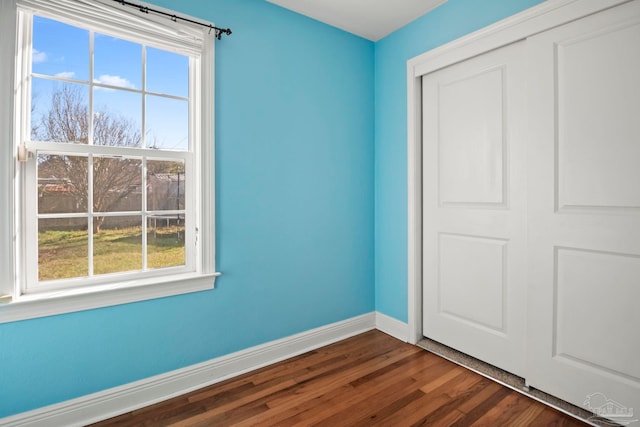 unfurnished bedroom featuring dark wood-type flooring and a closet