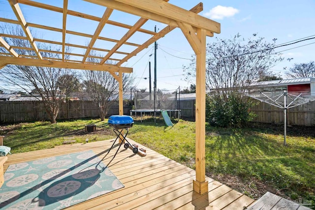 wooden terrace featuring a lawn and a trampoline