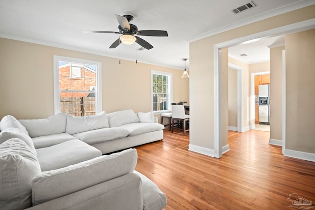 living room featuring ceiling fan, light hardwood / wood-style flooring, and ornamental molding