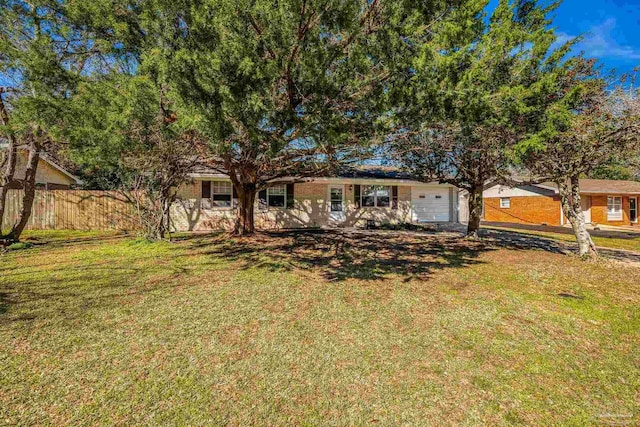 view of front facade with a garage, fence, and a front lawn