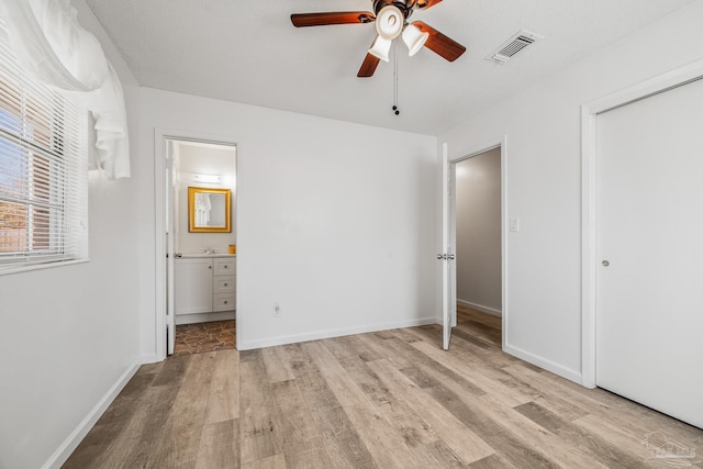 unfurnished bedroom featuring baseboards, visible vents, and light wood-style floors