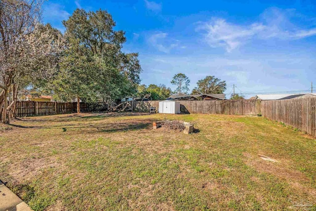 view of yard featuring a fenced backyard, an outdoor structure, and a storage unit