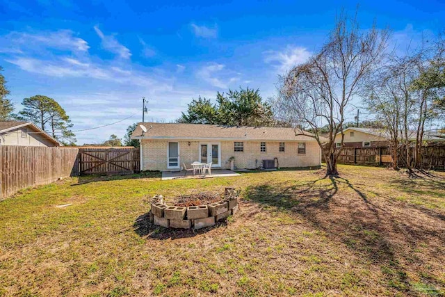 rear view of property with french doors, a patio area, a fenced backyard, and a gate