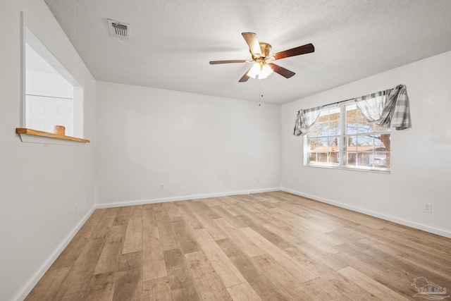 empty room with visible vents, baseboards, ceiling fan, a textured ceiling, and light wood-style floors