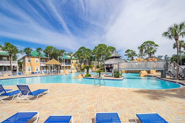 community pool with a gazebo and a patio
