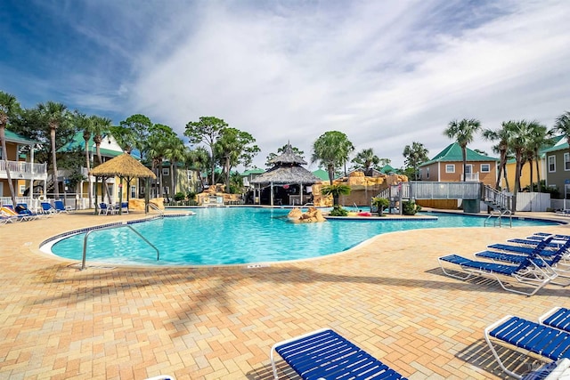community pool with a gazebo, fence, and a patio area