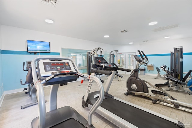 exercise room featuring wood finished floors, recessed lighting, and baseboards