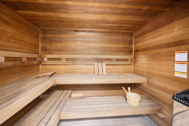 sauna featuring wooden ceiling and wooden walls