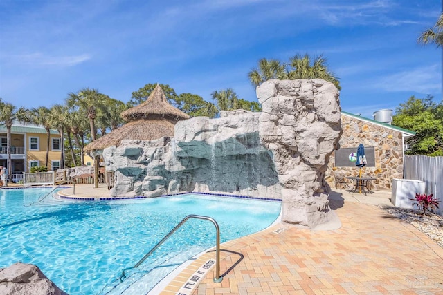 community pool with fence and a patio
