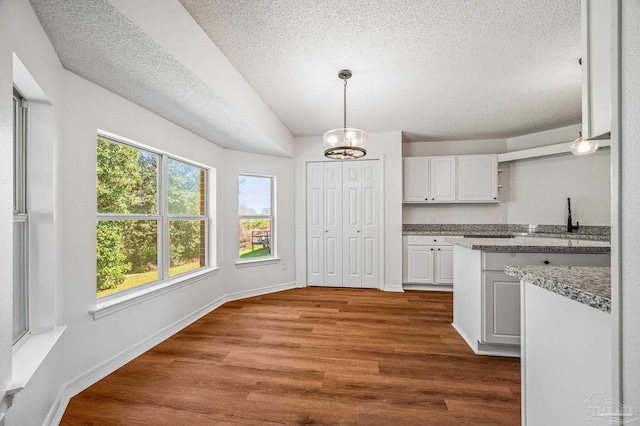 kitchen with baseboards, dark wood finished floors, pendant lighting, white cabinetry, and open shelves