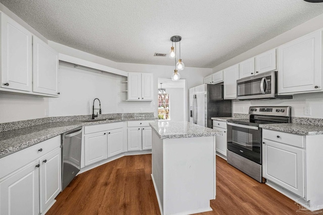 kitchen featuring visible vents, a sink, dark wood finished floors, appliances with stainless steel finishes, and open shelves