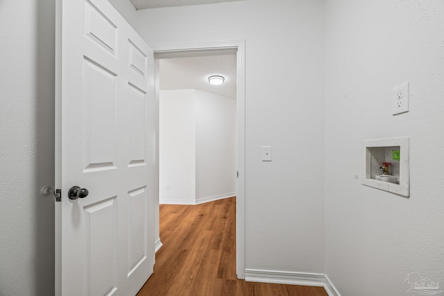 corridor with baseboards and wood finished floors