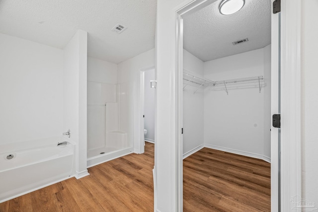 walk in closet featuring wood finished floors and visible vents