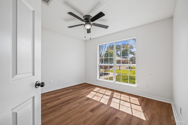 unfurnished room featuring visible vents, a textured ceiling, baseboards, and wood finished floors