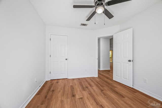 unfurnished bedroom with baseboards, visible vents, light wood finished floors, and ceiling fan