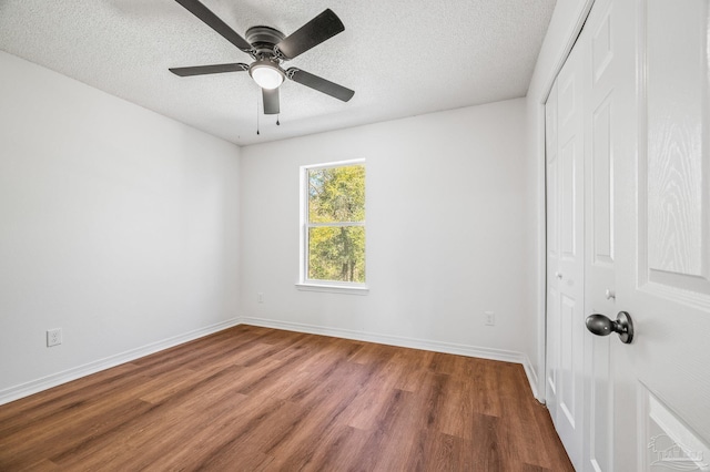 unfurnished bedroom with a closet, a textured ceiling, and wood finished floors