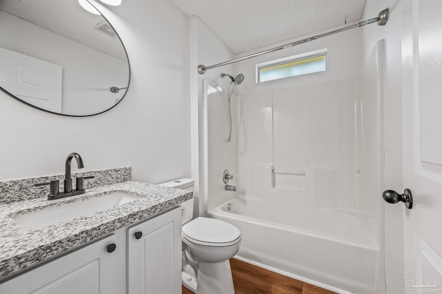 bathroom with visible vents, tub / shower combination, toilet, wood finished floors, and vanity