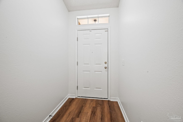 doorway to outside with dark wood-type flooring and baseboards