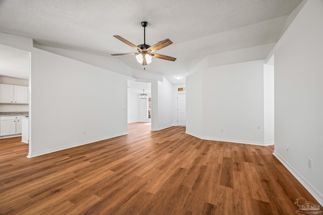 interior space featuring ceiling fan, baseboards, lofted ceiling, and wood finished floors