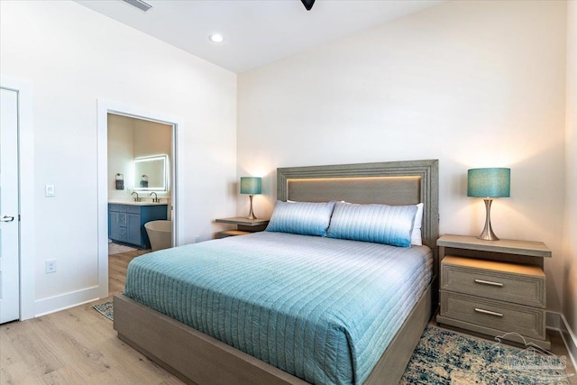 8169 White Sands Blvd, Navarre Beach, FL 32566 - bedroom featuring wood finished floors, baseboards, ensuite bath, recessed lighting, and a sink