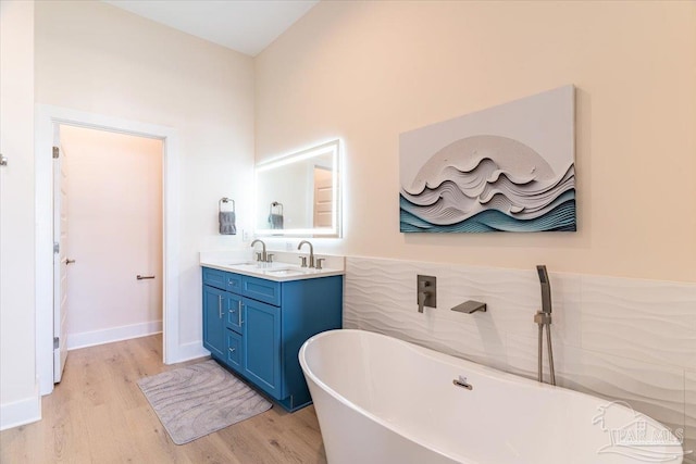 8169 White Sands Blvd, Navarre Beach, FL 32566 - bathroom featuring a freestanding tub, wood finished floors, and double vanity