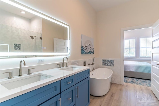 8169 White Sands Blvd, Navarre Beach, FL 32566 - full bath with a stall shower, double vanity, a freestanding bath, wood finished floors, and tile walls
