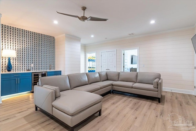 8169 White Sands Blvd, Navarre Beach, FL 32566 - living room featuring beverage cooler, a ceiling fan, ornamental molding, light wood-style floors, and a dry bar