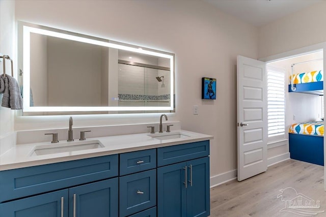 8169 White Sands Blvd, Navarre Beach, FL 32566 - full bath featuring double vanity, wood finished floors, a tile shower, and baseboards
