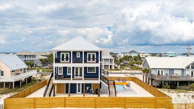 8169 White Sands Blvd, Navarre Beach, FL 32566 - rear view of property with a balcony, a fenced backyard, stairs, a residential view, and a patio area