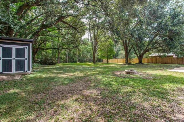 8818 Klondike Rd, Pensacola, FL 32526 - view of yard with a fire pit and a storage shed