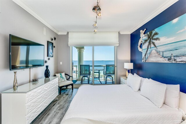 bedroom featuring access to outside, a water view, wood-type flooring, and crown molding