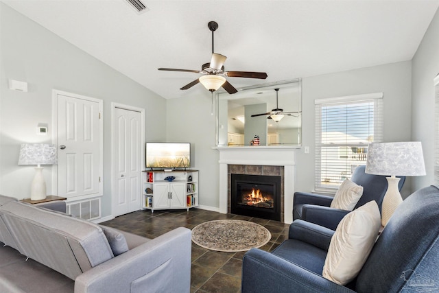 living room featuring a tiled fireplace, ceiling fan, and lofted ceiling