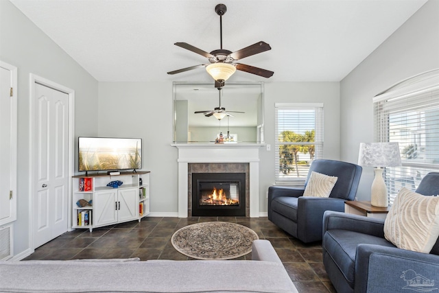 living room with ceiling fan and a fireplace