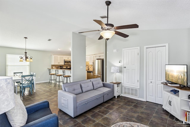 living room featuring ceiling fan with notable chandelier and vaulted ceiling