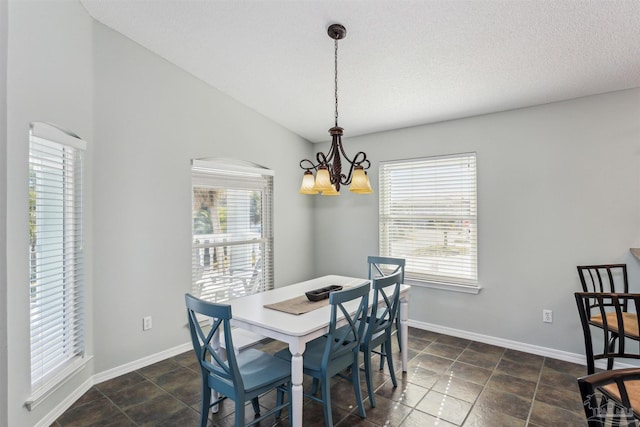 dining space with a textured ceiling, lofted ceiling, and a notable chandelier