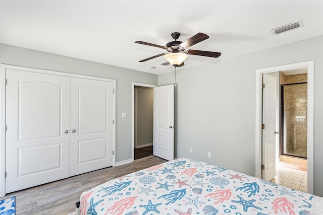 bedroom featuring ceiling fan, a closet, a textured ceiling, and light wood-type flooring