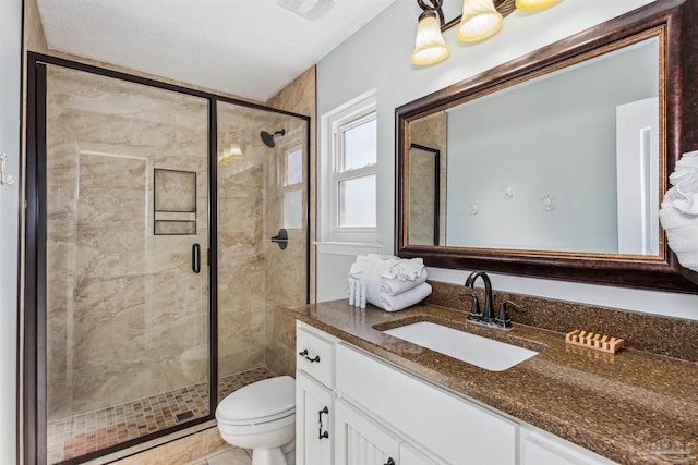 bathroom featuring a shower with door, vanity, and toilet