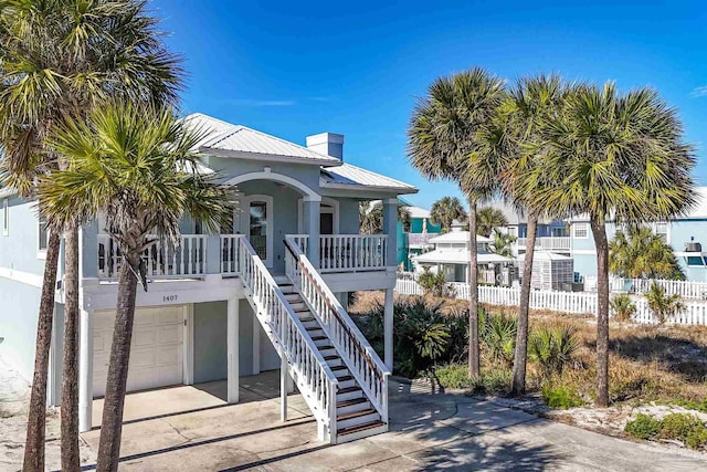 raised beach house with covered porch and a garage