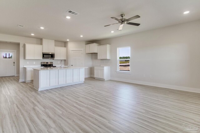 9797 Windyhill Rd, Pensacola, FL 32526 - kitchen featuring stainless steel appliances, baseboards, light wood-style flooring, a sink, and white cabinets