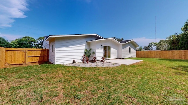 back of property with a yard and a patio